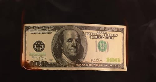 US-Dollar-Notengeld brennt im Feuer, das Konzept der Wirtschaftskrise der Inflation und