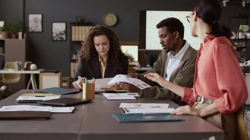 Business Team Reviews Documents Together at Conference Table
