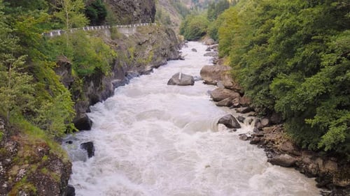 Rushing river flowing through scenic mountain valley