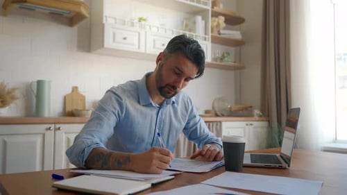 Man Working at Home on Laptop with Coffee