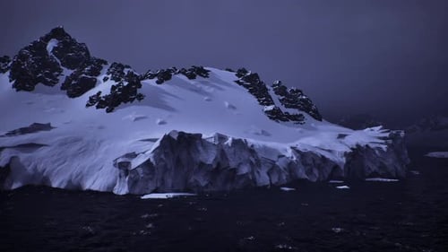 Majestic Antarctic Glacier Above Restless Sea Under Heavy Clouds