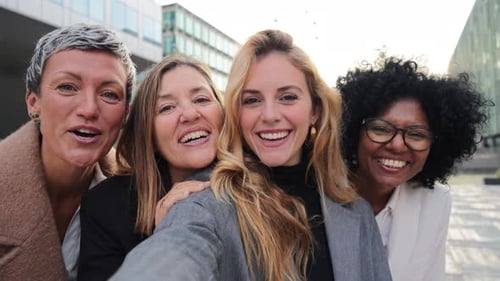 Four Cheerful Women Waving to the Camera