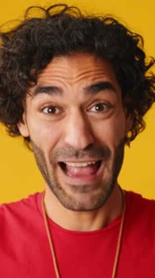 Close up, wonder man put his hands on head looking at camera isolated on yellow background