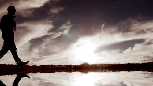 Silhouette of Man Walking in Nature Landscape Hiking with Cloudscape Sky