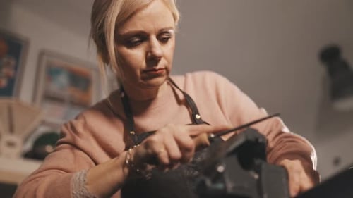 Konzentrierte Handwerkerin beim Metallfeilen in der Werkstatt