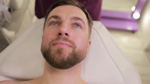 A Man is Enjoying a Rejuvenating Facial Treatment in a Serene and Modern Spa Environment