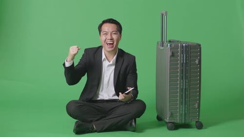 Businessman With Luggage Screaming Goal Celebrating While Sitting In The Green Screen