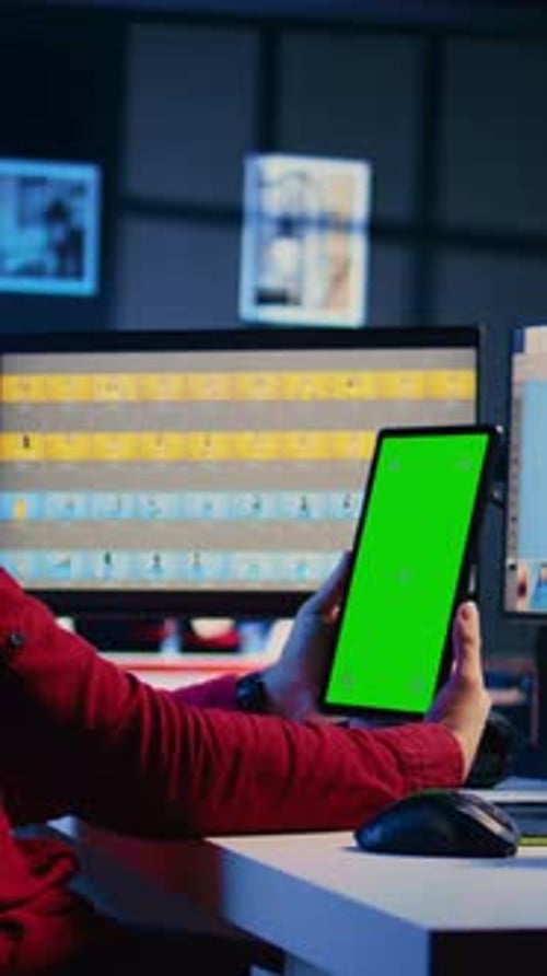Editor Holds Tablet with Green Screen in Office