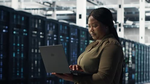 Engineer Using Laptop in Data Center Integrating New Technologies