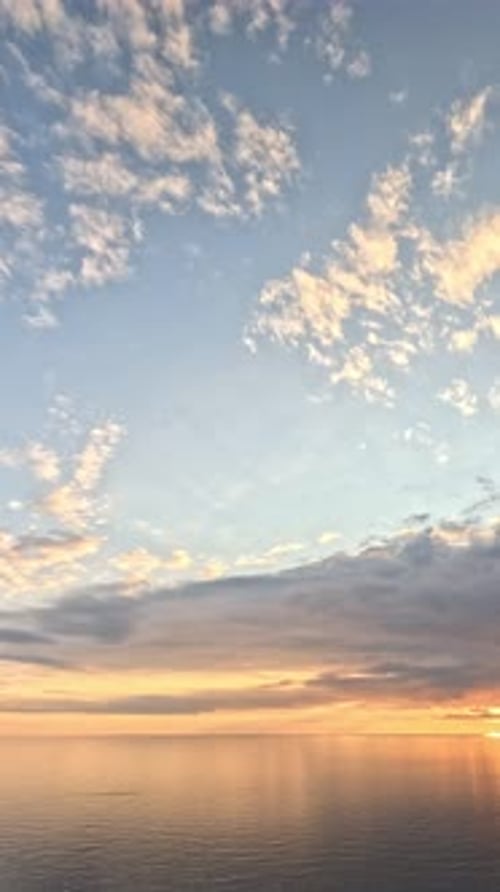 Timelapse : cumulus moelleux se déplaçant dans un ciel doré brillant au coucher du soleil au-dessus de la mer, nature aérienne abstraite