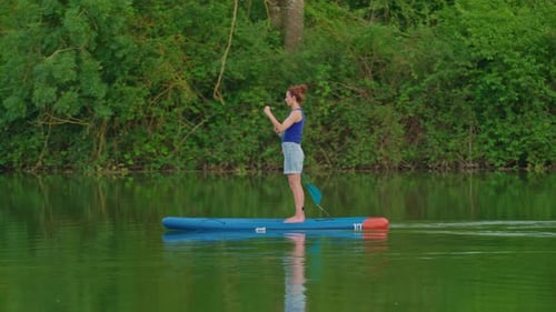 Alone Woman Floating on Stand Up Paddle Board in Lake in Summertime Standup Paddleboarding Surfer