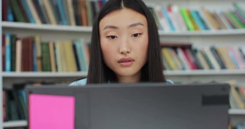 Student Studies with Laptop in Library