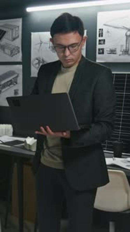 Vertical d'un ingénieur de sexe masculin avec un ordinateur portable observant un nouveau prototype de panneau solaire
