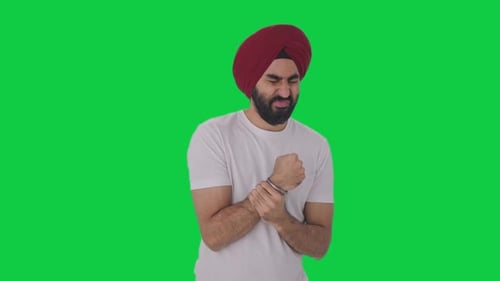 Sick Sikh Indian man suffering from hand pain Green screen