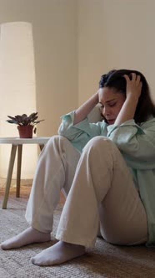 Woman Sitting on Floor Running Hands Through Hair