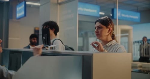Multiethnic Passengers at Airport Checkin Counter Female Airline Worker Checking Documents