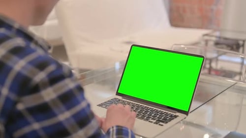 Young Man Using Laptop with Green Screen