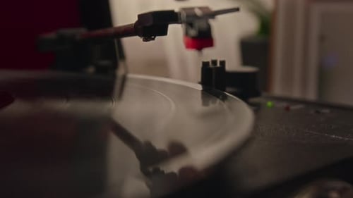 Close-up of Mans Hand Placing Tone Arm on Vinyl Record while Starting Turntable
