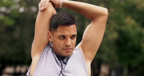 Young Man Stretching Arms Outdoors in Green Park