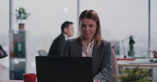 Businesswoman Working on Laptop in Bright Modern Office