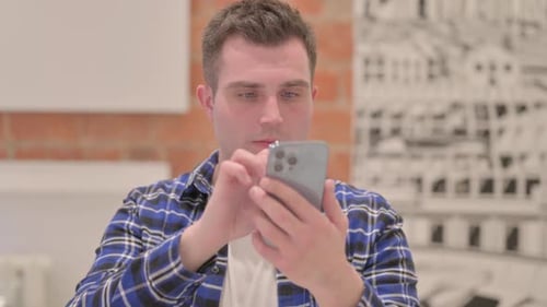 Portrait of Young Casual Man using Smartphone