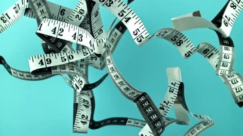 Measuring Tapes Floating in Mid-Air Against Blue Backdrop
