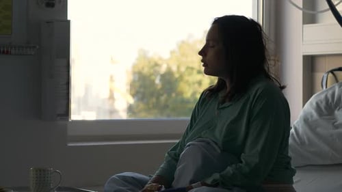 Perfil de la mujer embarazada a la espera de dar a luz en una habitación de hospital