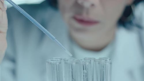 Scientist Drops Liquid into Test Tubes