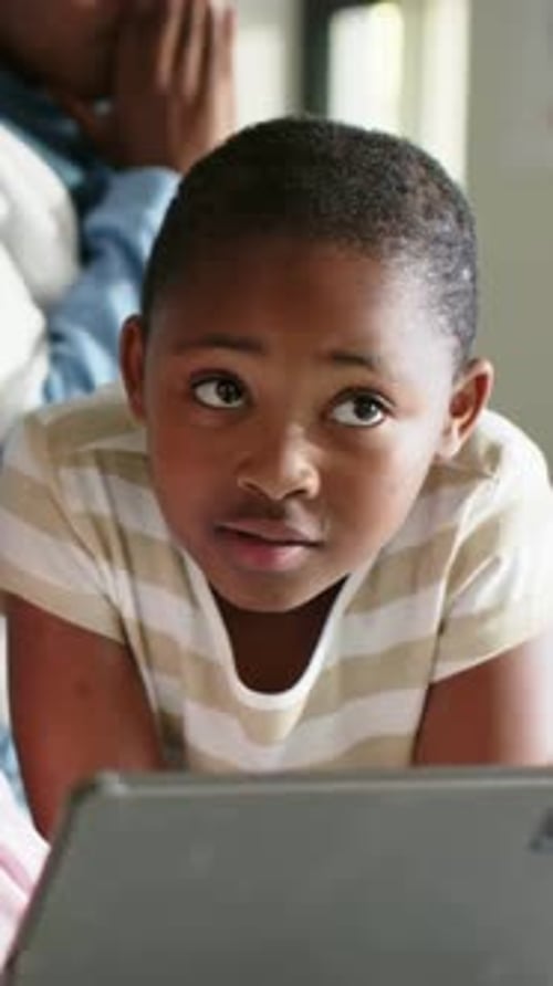 Vertical video: Hearing nearby sound, girl looking up from tablet in class, striped, male reacting
