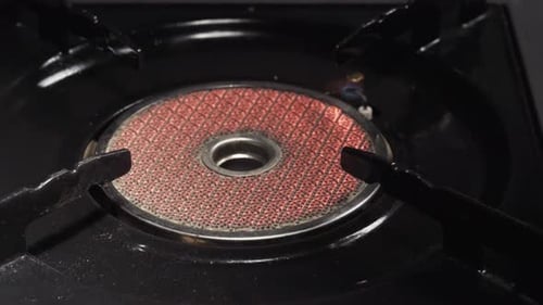 Portable gas ceramic stove for cooking, camping, put frying pan on fire, Oil, slide shot, close up