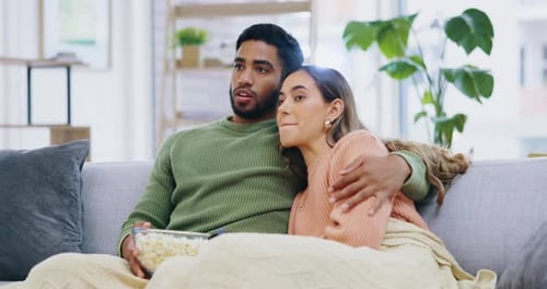 Couple Watching Exciting Movie at Home on Couch
