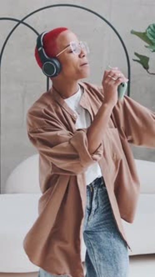 Woman with Headphones Dances Holding a Phone