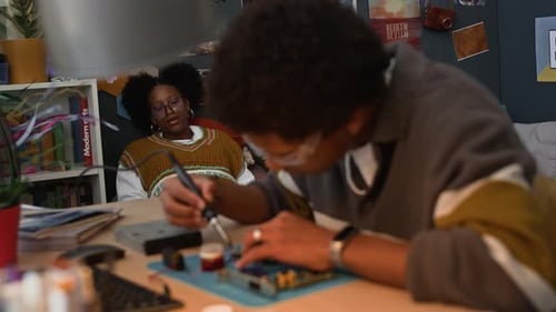 Young Adult Soldering Circuit Board at Home