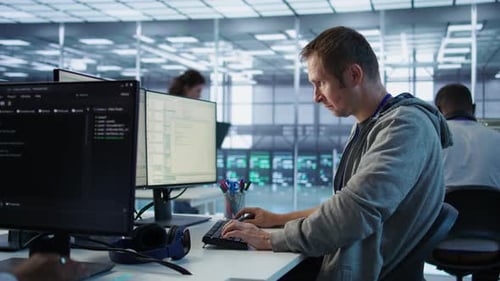 Portrait of Smiling Engineer Inspecting Server Rows in Data Center
