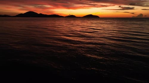 An aerial shot of a sunset over the ocean.
