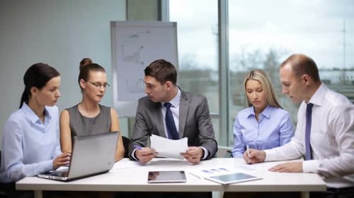 Business Team Meeting Discussing Charts and Data