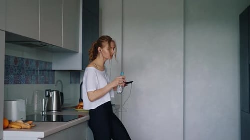 Woman Drinking Water and Using Mobile Phone