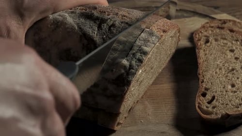 Slicing Fresh Bread on a Wooden Cutting Board