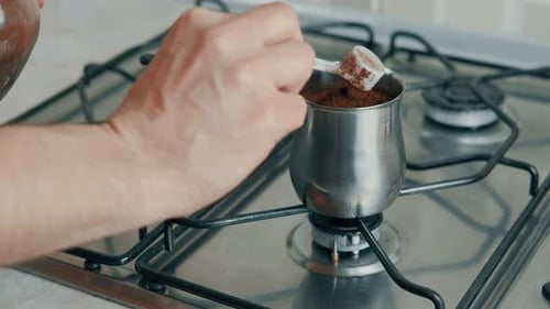 Adding Coffee to Pot on Stove Indoors