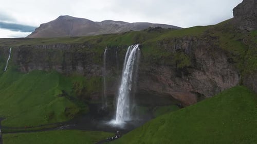 Aerial View of Seljalandsfoss Waterfall with Visitors and Lush Terrain