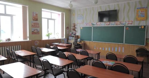 Pan Across Empty Classroom in School Chairs and Desks Without Anyone Sitting Vacant Room Elementary