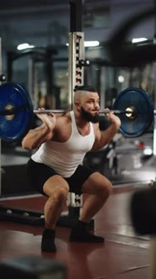 Powerful Athlete Performing Intense Barbell Squats Demonstrating Muscular Strength and Unwavering