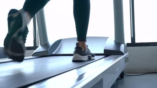 Exercise treadmill cardio running workout at fitness gym of woman taking weight loss