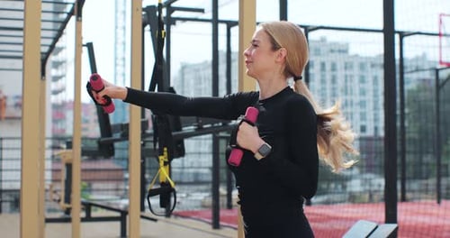 Woman Doing Arm Exercises with Pink Dumbbells