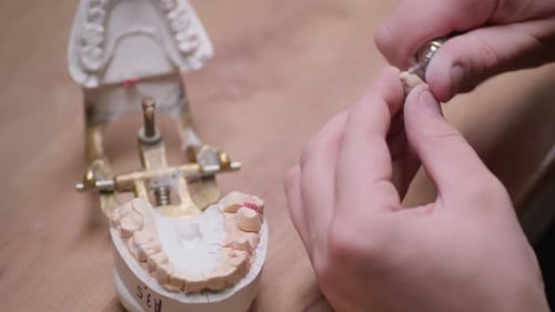 Hands Crafting Dentures with Precision Rotary Tool