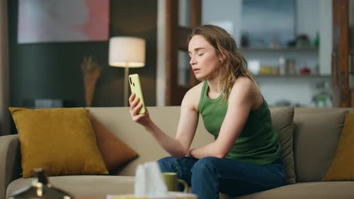 Woman Using Smartphone Looking Upset on Couch
