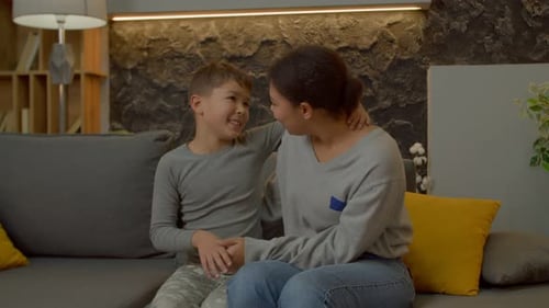 Woman and Child Holding Hands on Sofa