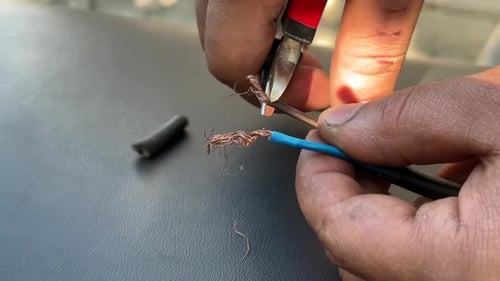Hands Strip Electrical Wire with Wire Cutters