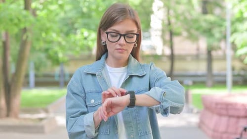 Young Woman Checking Her Smartwatch in a Park