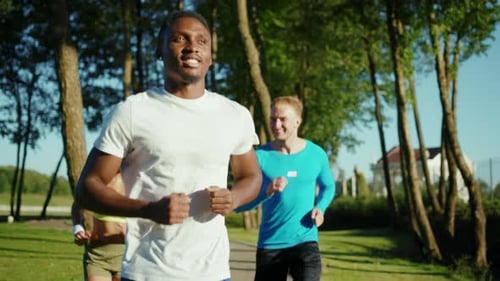 Group of Three Amazing Athletic People Running Together Training for Future Marathon Doing Physical